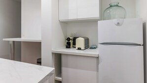 A modern kitchen with white cabinetry, a built-in oven, and a glass vase on the countertop. - Cosy Apartment - 1br/4p - Near Nation (Paris)