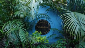 Une plaque sur un mur bleu portant l’inscription : « Madhuban » de Deshmukh.