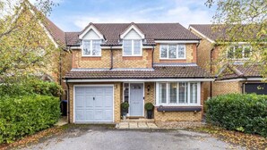 A two-story house with a garage, a front porch, and a brick facade. - Homely 4 Bedroom House Addlestone (Addlestone)