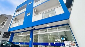 Un edificio moderno con facciata blu e bianca, ampie finestre e condizionatori d'aria.