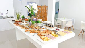 Un tavolo da buffet con diversi cibi e una pianta decorativa.