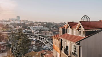 A cityscape with a prominent bridge and traditional buildings with red-tiled roofs.