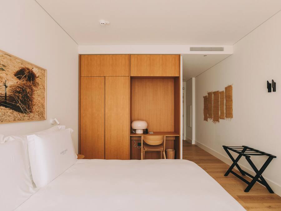 Un dormitorio con cama, escritorio y armario.