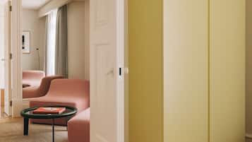 Una sala de estar moderna con piso de madera, un sofá rosa, una mesa de centro verde y un armario amarillo.
