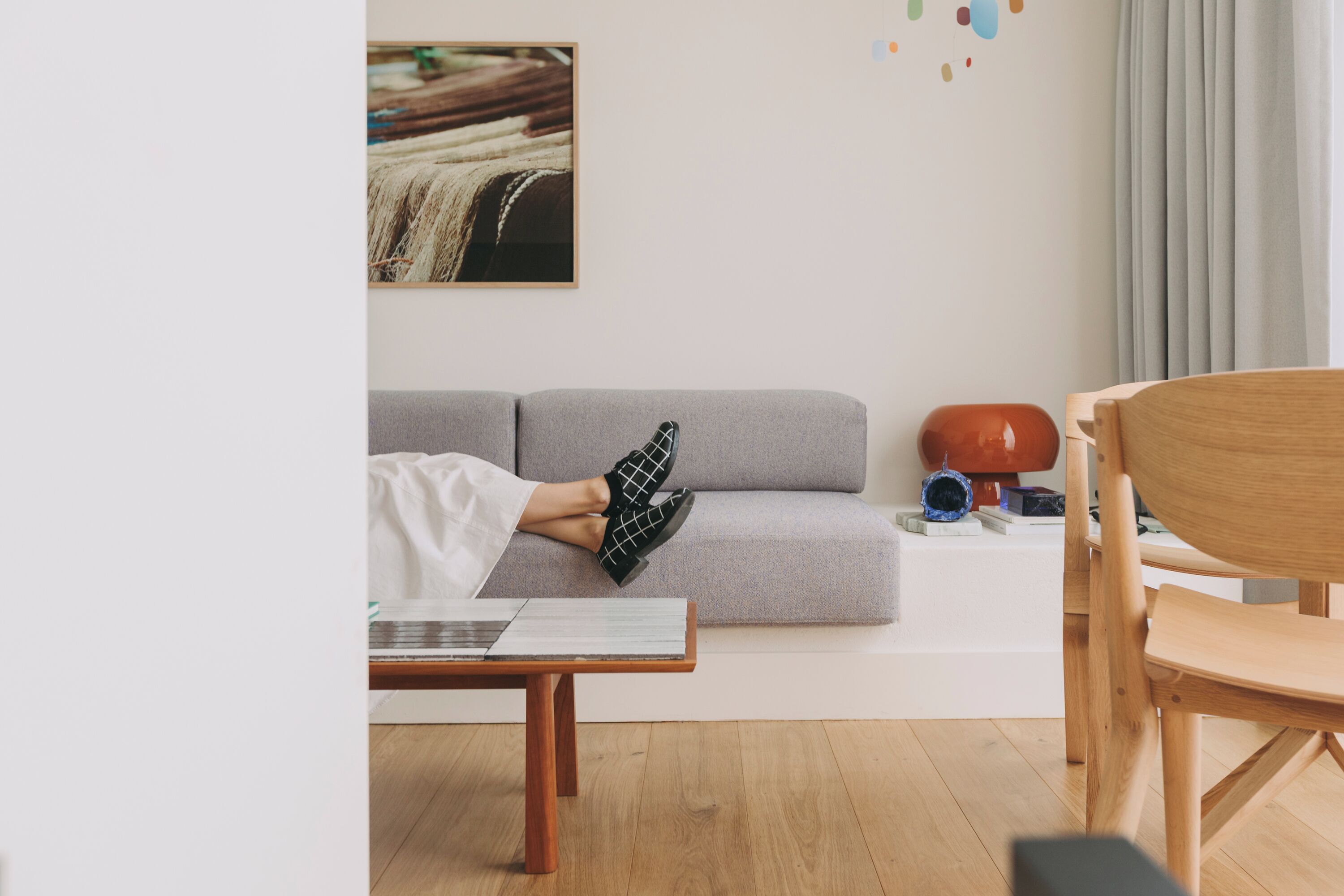 Un salon avec un canapé gris, une table basse en bois et une chaise en bois.