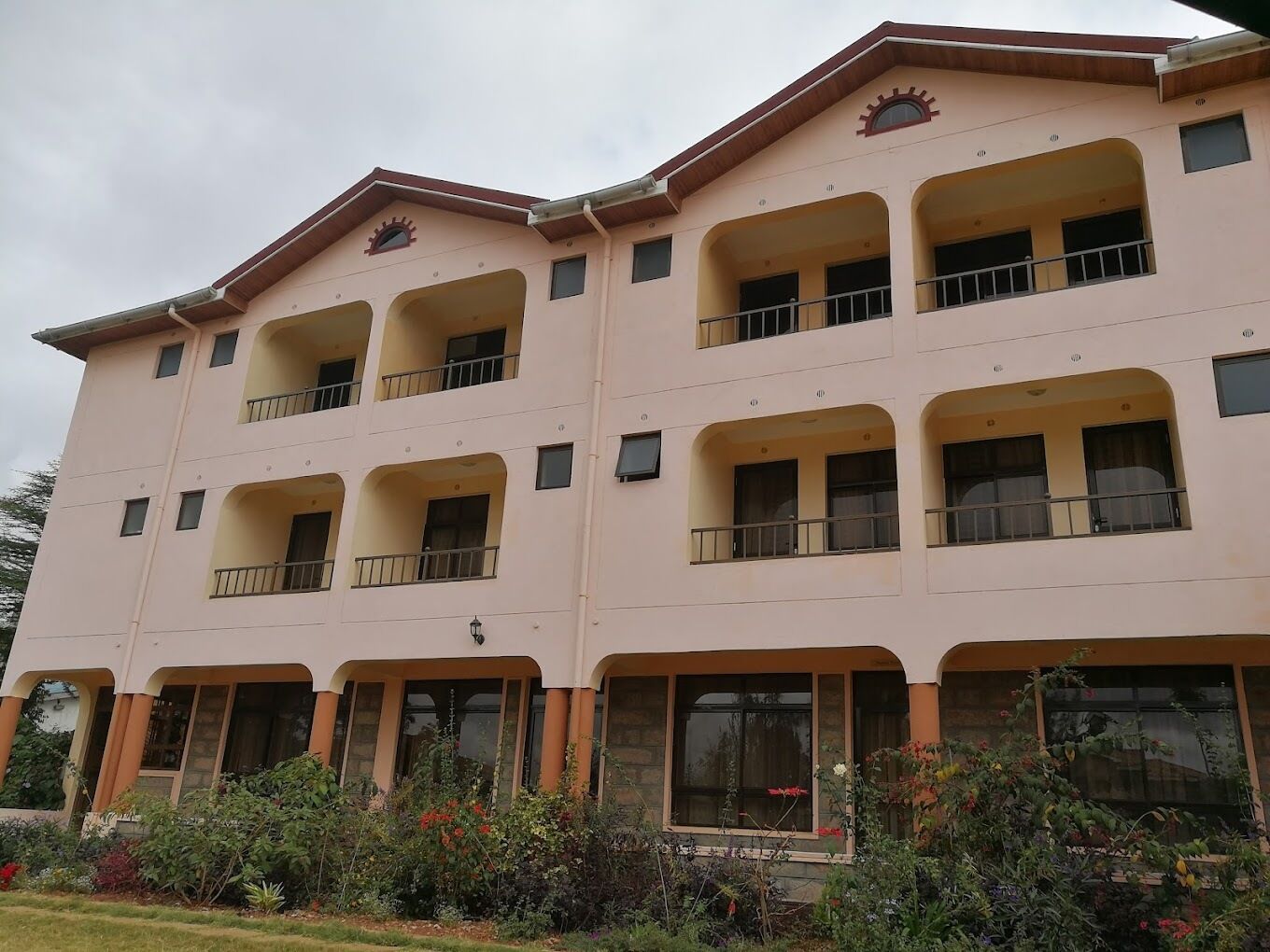 A multi-story hotel with balconies and large windows.