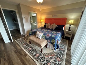 A bedroom with a bed, bedside lamps, a nightstand, a bench, a rug, and a door leading to another room. - Lake Keowee Getaway with Dock Access, Pool & Mountain Views (Six Mile)