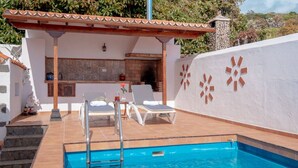 Una piscina con sillas de descanso y una pequeña zona de bar.