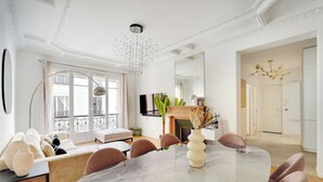 A modern dining area with a marble table, comfortable seating, and a large window with curtains. - Beautiful Apartment - 2bd/4p - Arc de Triomphe (Paris)