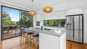 A modern kitchen with a large island, stainless steel appliances, and a view of the outdoors. - Anglesea Summer Escape (Anglesea)
