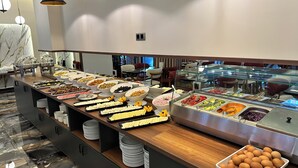 En buffet med forskelligt mad og et glasmontér.