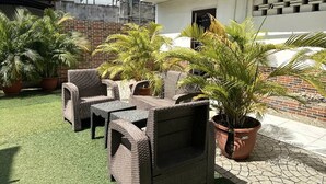 A patio with wicker furniture and potted plants. - The Autograph Basics Hotel (Lagos)