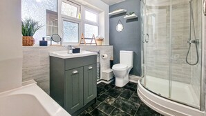 Ein modernes Badezimmer mit Badewanne, Toilette und einer Duschkabine.
