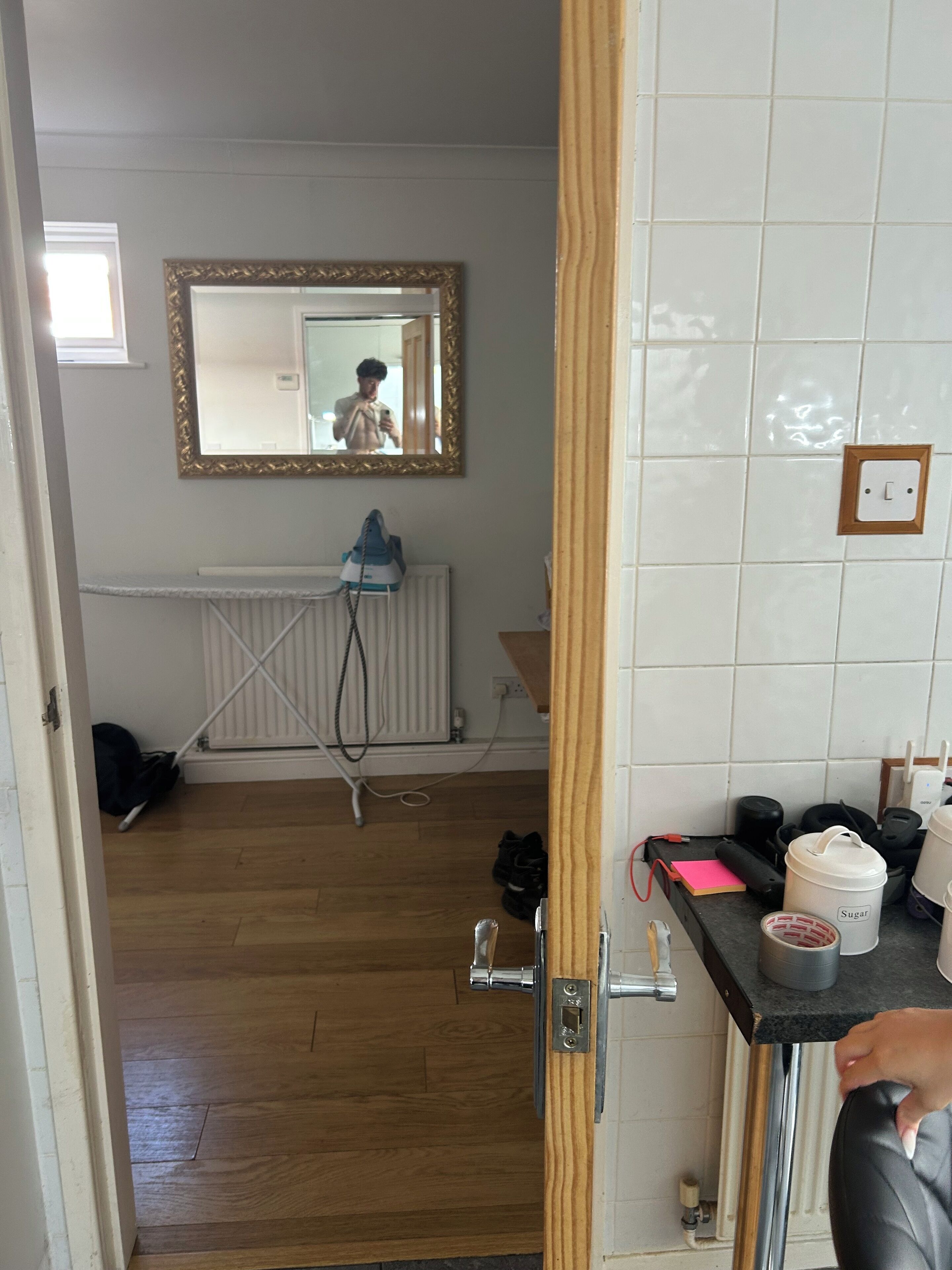 Une salle de bain avec un miroir, un radiateur et divers produits de toilette disposés sur le comptoir.