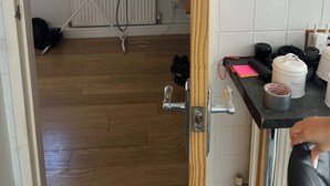 Ein Badezimmer mit Spiegel, Heizkörper und verschiedenen Pflegeprodukten auf der Ablagefläche.