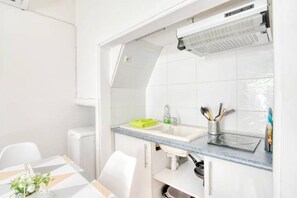 A modern kitchen with white cabinets, a grey countertop, and a built-in sink.