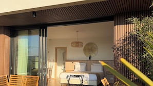 Une chambre moderne avec un grand lit, une petite table et deux chaises.