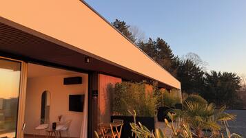 A modern house with a large glass door leading to a patio area.
