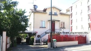 Un edificio residencial con una reja roja, una escalera y una puerta visible.