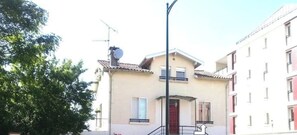 A residential building with a red gate, a staircase, and a visible door.