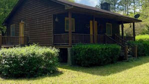 Une cabane rustique avec une façade en bois, une véranda et une cheminée.