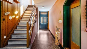 Una escalera de madera que lleva a una puerta con la inscripción 'Balcón'.