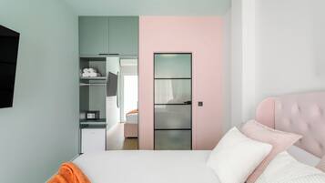 Un dormitorio con cama, armario y puerta que da a un baño.