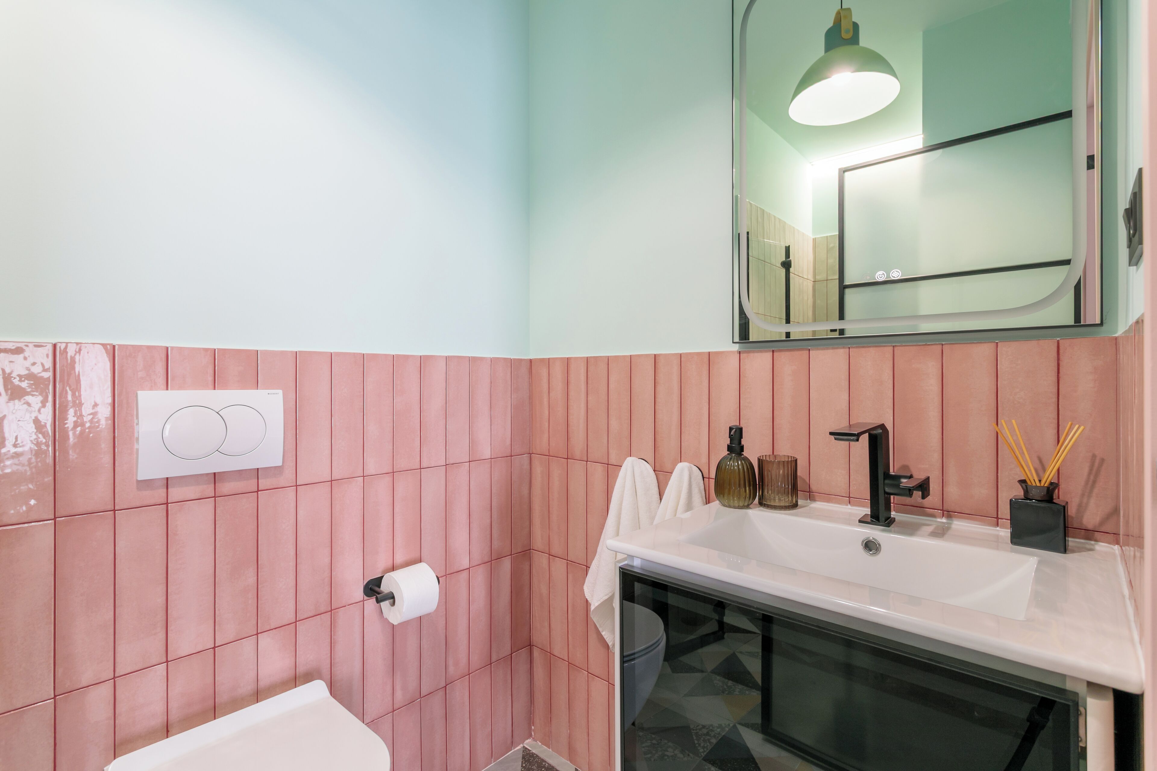 A bathroom with a white sink, a mirror, a towel rack, and a toilet.