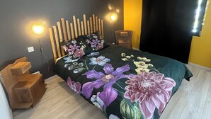 A bedroom with a bed, wooden headboard, bedside tables, and a nightstand. - Apartment with terrace for 2 people Le nid du phénix 38 in the countryside (Arandon-Passins)