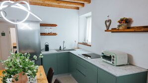 Eine Küche mit Einbaukühlschrank, Spüle, Toaster und einem Fenster mit Vorhängen.