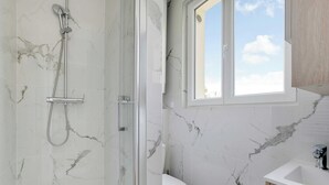 A bathroom with a shower, toilet, and sink, featuring marble walls and a window. - Cosy Apartment - 1bdr-4p - Ivry-sur-seine (Ivry-sur-Seine)
