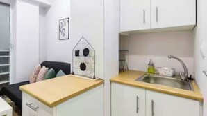 A compact kitchen with white cabinets, a sink, and a countertop. - Charming studio in Athens 25sqm (Athina)