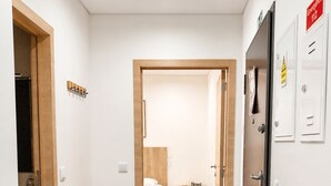 A hallway with a bench, a bed, and a refrigerator. - Fatima Experience 50 meters from the Sanctuary of Fátima (Fátima)
