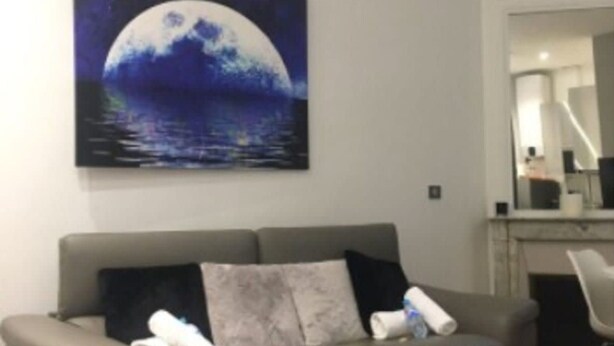 A living room with a grey sofa, a coffee table, and a painting of a moon over water on the wall. - Cozy Apartment - 1br/4p - Trocadero/eiffel Tower (Paris)