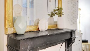A black marble fireplace with white vases and a framed artwork on the mantel. - Cosy Studio - 2P - Place de la Concorde - Saint-honore (Paris)