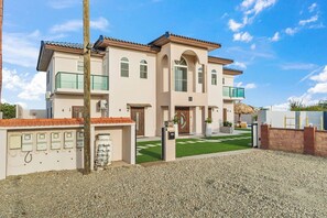 A two-story building with a flat roof, multiple windows, and a gated entrance.