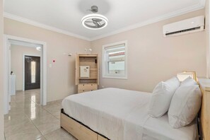 A bedroom with a bed, a ceiling fan, an air conditioning unit, a wardrobe, and a window. - Pool Table * Private pool * Sleeps 16 (Oranjestad)