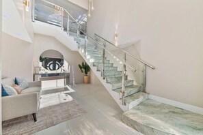 A spacious living area with a staircase leading to an upper floor.
