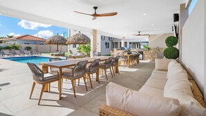 Un espace piscine extérieur avec des chaises longues et une table à manger.