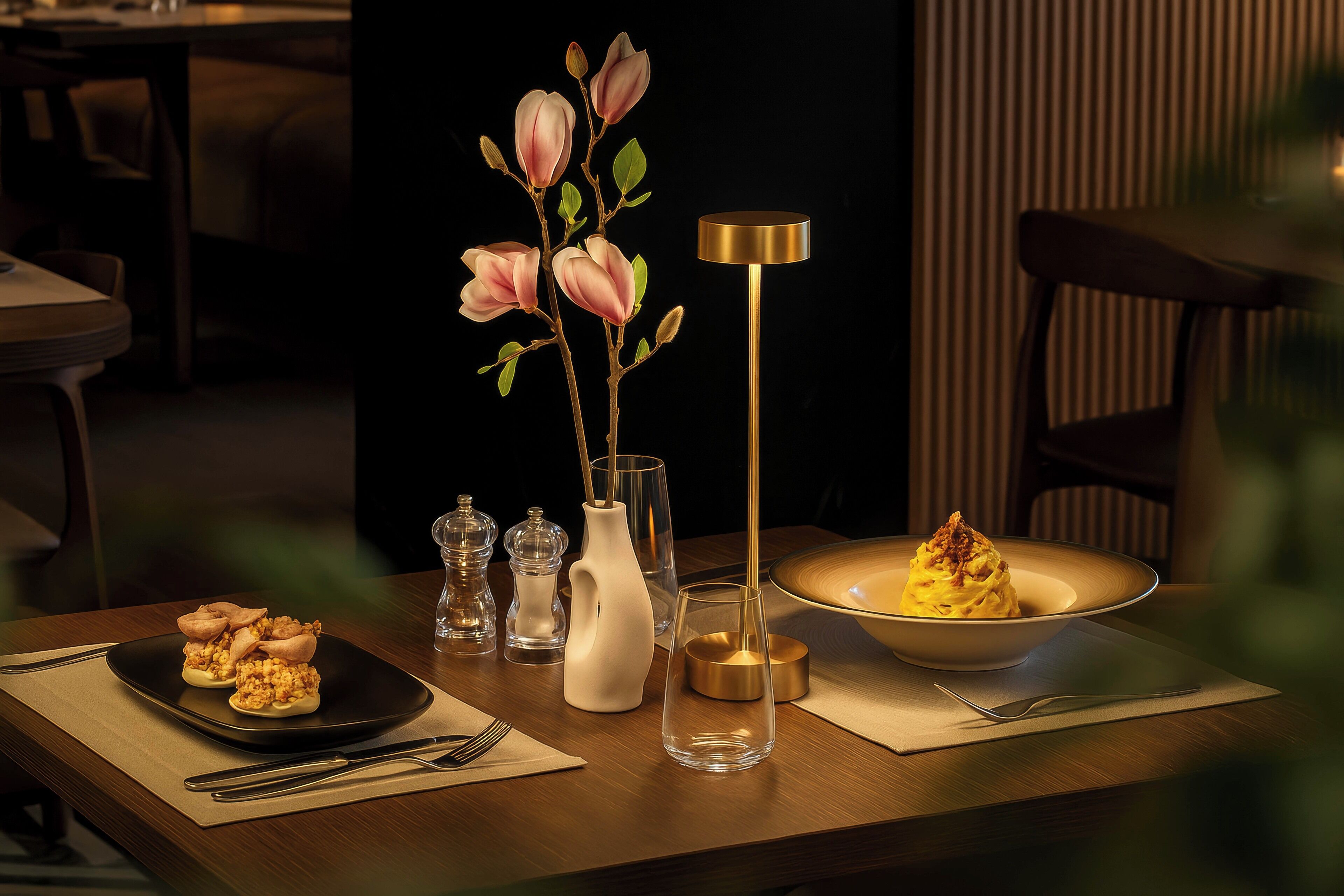 A dining table with a plate of food, a vase with flowers, and a tall lamp.