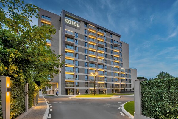 A modern hotel with a prominent 'One66' sign, featuring a clean, rectangular design with multiple balconies and large windows. - ONE66 (Brașov)