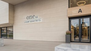 A modern luxury apartment hotel entrance with a clean, minimalist design. - ONE66 (Brașov)