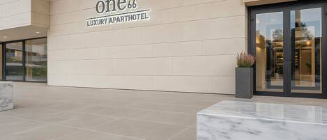 A modern luxury apartment hotel entrance with a clean, minimalist design.