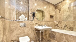 A bathroom with a marble wall, a round mirror, a sink, a toilet, and a shower area. - Authentic Apartment - 2br/6p - Near Opera Garnier (Paris)