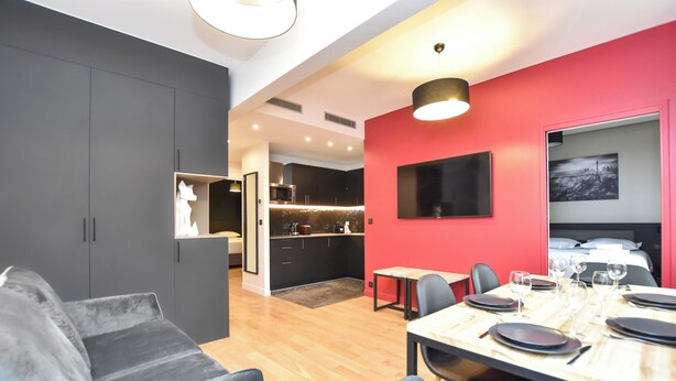 A modern hotel room with a dining area, a kitchen, and a living space. - Authentic Apartment - 2br/6p - Near Opera Garnier (Paris)