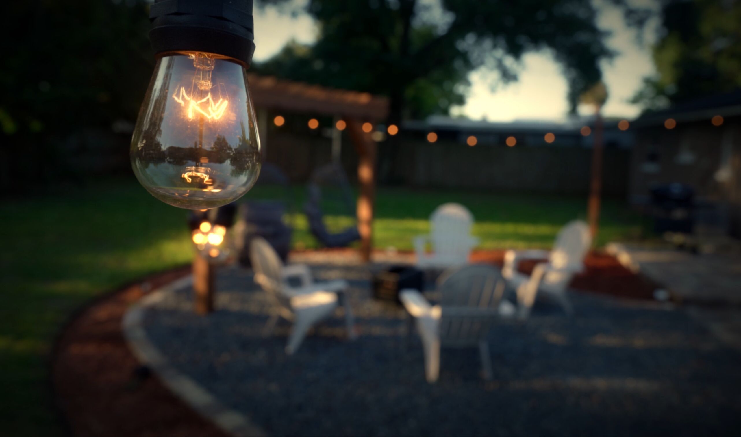 Un espace patio avec des sièges d’extérieur et des guirlandes lumineuses.