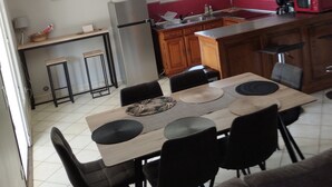 A compact kitchen with a dining area, featuring a refrigerator, microwave, and wooden cabinets. - Lovely apartment with swimming pool and exterior (Gabian)