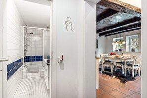 Un bagno con piastrelle bianche e azzurre, una doccia e un WC.