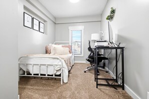A bedroom with a bed, a desk, and a computer setup. - Vernal Sport Court Base Camp (Vernal)