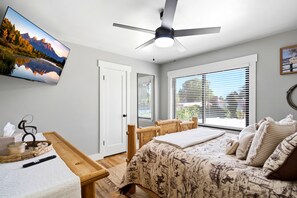 A bedroom with a bed, a desk, a chair, a ceiling fan, and a window with blinds. - Vernal Sport Court Base Camp (Vernal)